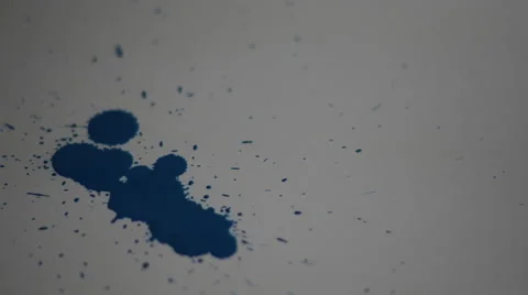 4K Blue paint splashed onto white paper, droplets everywhere Stock Footage 63135350