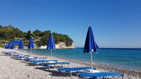 4K Blue sunbeds and umbrellas on quiet beach Stock Footage 114278053