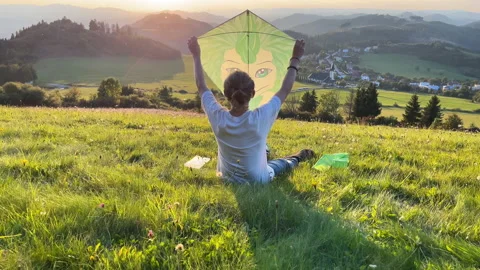 4K Boy sitting down on grass raising up his kite above his head with two hands Stock-Footage 235924501