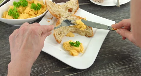 4K Breakfast Clip. A cut open croissant and some scrambled eggs lie on plate Stock Footage 65762433