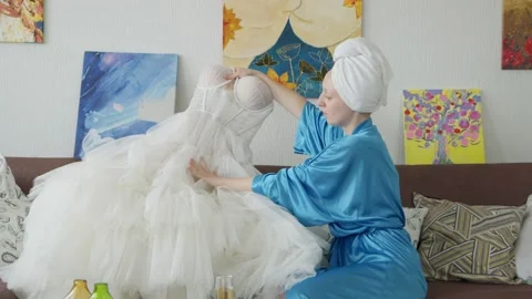 4K. A bride in a bathrobe tries on a wedding dress Stock Footage 201958858