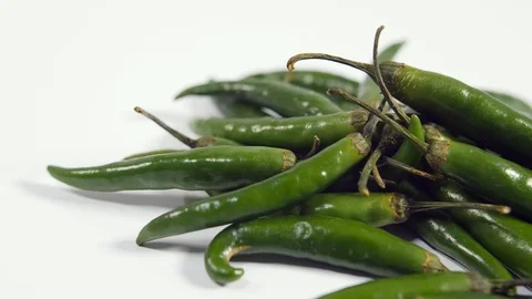 4K bright green chilli peppers against white background, pan birds eye spices Stock Footage 88492212