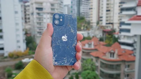 4k, broken Apple iPhone in hand on the background of the city Stock Footage 229792144