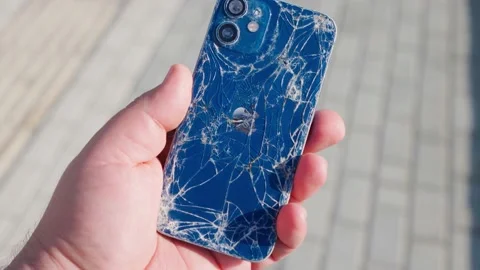 4k, broken Apple iPhone in hand on the background of the sidewalk Stock Footage 230994827