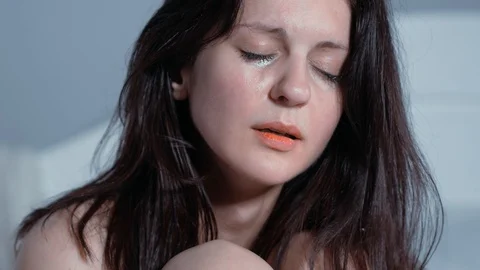 4k, brunette woman crying on the bed, scene after rape, naked lady crying after Stock Footage 99148564