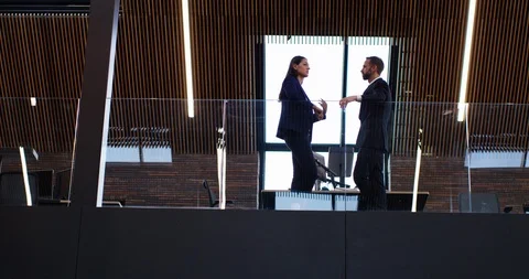 4K Business couple in conversation in front of window in modern office space Stock Footage 118961682