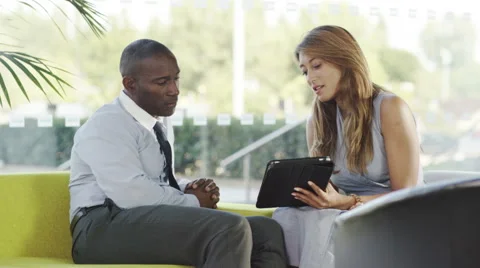 4k Business man and woman having a discussion and looking at computer tablet Stock Footage
