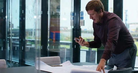 4K Businessman in boardroom discussing data from sales report over the phone Stock Footage 118735897
