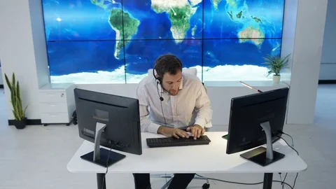 4K Businessman having conversation via headset with world map in background Stock Footage 75952437