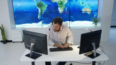 4K Businessman having conversation via headset with world map in background Stock Footage 75952619