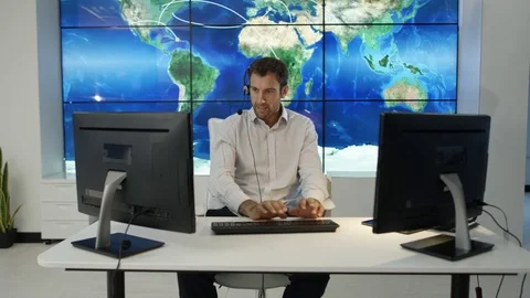 4K Businessman having conversation via headset with world map in background Stock Footage 75952838