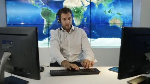 4K Businessman having conversation via headset with world map in background Stock Footage 75953554