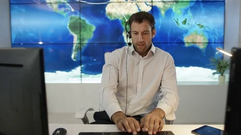4K Businessman having conversation via headset with world map in background Video stock 75955832