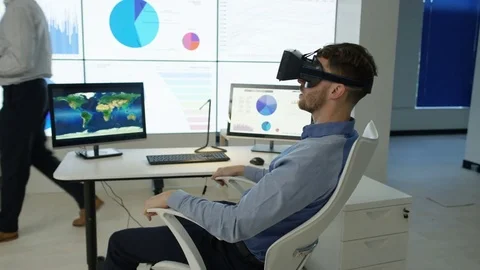 4K Businessman interacting with a virtual reality headset in futuristic office Stock Footage 75977829