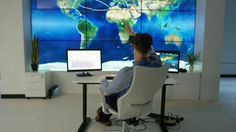 4K Businessman interacting with a virtual reality headset in futuristic office Stock Footage 75979091