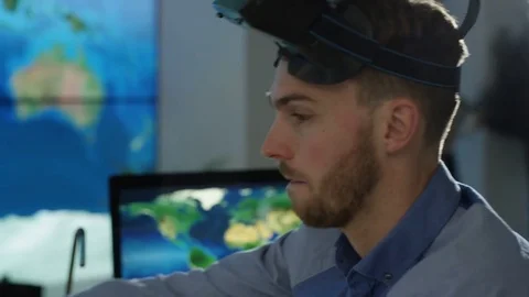 4K Businessman interacting with a virtual reality headset in futuristic office Stock Footage 75979447