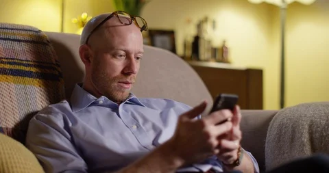 4k Businessman using a cellphone while relaxing at home. Stock Footage 128378844
