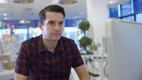 4K Businessman working on computer at his desk in creative office Stock Footage 75998183