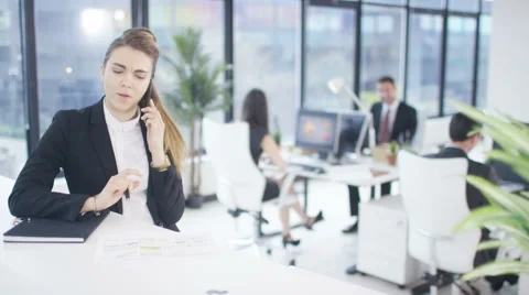 4K Businesswoman making phone call & talking to colleagues in city office Stock Footage