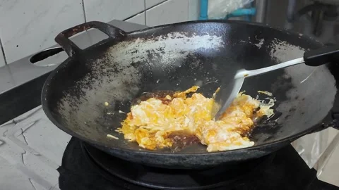 4K Camera footage Stirring scrambled eggs in black wok Stock Footage 325649587