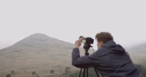 4K Camera Man in the Scottish Glen Coe Mountain Highlands. Tourist with tripod. Stock Footage 93028488