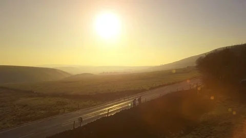 4k Camera rises up as two hikers walk toward sunset in beautiful landscape Stock Footage 105406113