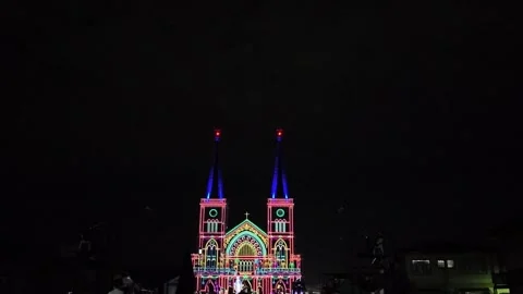 4K Camera video of colorful light projection on cathedral facade at night Stock Footage 325649178