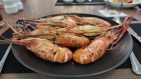 4K Camera video of grilled river prawns served on black plate Stock Footage 325720634