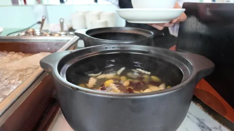 4K Camera video of ladle scooping herbal soup from hot pot Stock Footage 325720736
