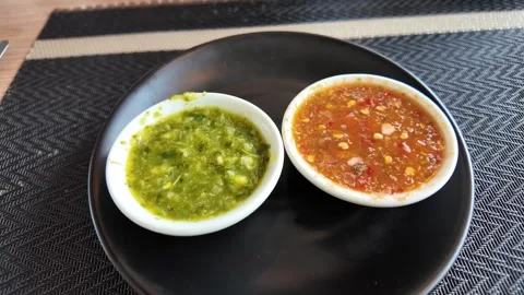 4K Camera video of two Thai dipping sauces in small bowls on black plate Stock Footage 325720725