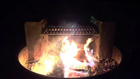 4K Campfire with Grilling Setup  Cozy Outdoor Scene with Wood Burning Stock Footage 255483513