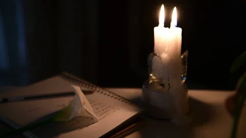 4k The candle is burning, on the table lies a notebook with verses Stock Footage 156757774