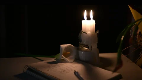 4k The candle is burning, on the table lies a notebook with verses Stock Footage 156758168