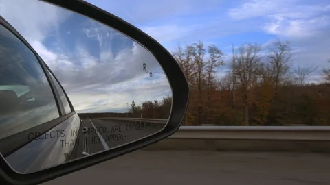 4K. Car mirror while driving on the long road through the beautiful. Stock Footage 123539035