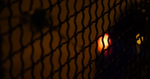 4K CAR TAIL LIGHT HAZARDS BLINKING AT NIGHT THROUGH A FENCE Video stock 131280148