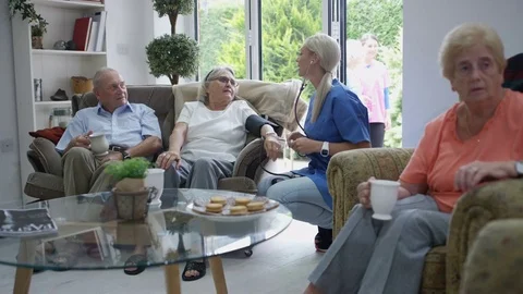 4K Caring nurse checking elderly lady's blood pressure in nursing home Stock Footage 73291585