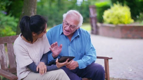 4K Caring young home support worker showing elderly man how to use a computer Stock Footage 56563816