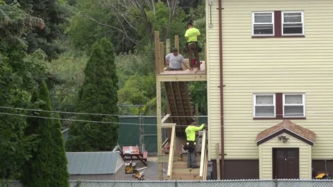 4K Carpenters build two level porch and staircase to back of house Stock Footage 159818569