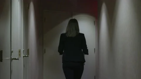 4K carrying banker box down dark hallway office building Stock Footage 233632428