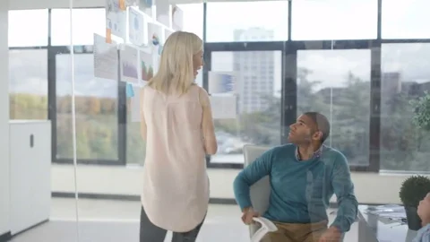 4K Casual business group in a meeting looking at printed graphs & brainstorming Stock Footage