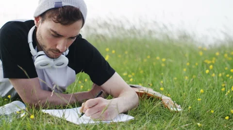 4K Casual man writing on a notepad in a meadow Stock-Footage 63899657