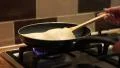 4K caucasian hand with spatula pushes pancake around a pan 4k or 4k+ Resolution