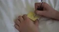 4K caucasian hand writes ""do dishes"" on post it note and removes it from stack 4k or 4k+ Resolution