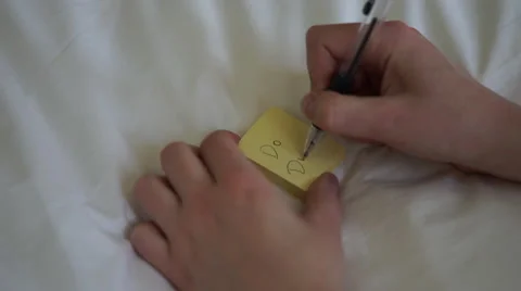 4K caucasian hand writes ""do dishes"" on post it note and removes it from stack Stock Footage 63121062