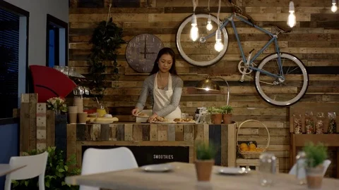 4K Cheerful cafe worker wiping down tables. Happy small business owner. Stock Footage 76604974