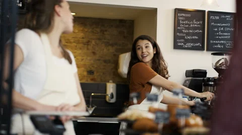 4K Cheerful worker serving a customer who uses smartphone to pay in coffee shop. Stock Footage 61841673