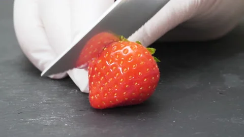 4K - Chef cuts a strawberry with a knife. Close-up Stock Footage 165510904