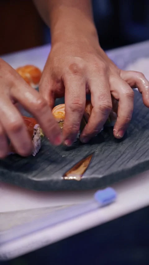 4K chef plating 8 pieces salmon sushi roll with hands - vertical video  Stock Footage 314682776