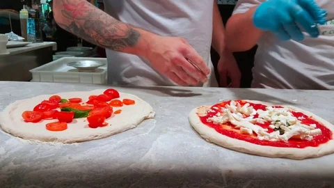 4K Chef preparing pizza in a indoor restaurant Stock Footage 84076372