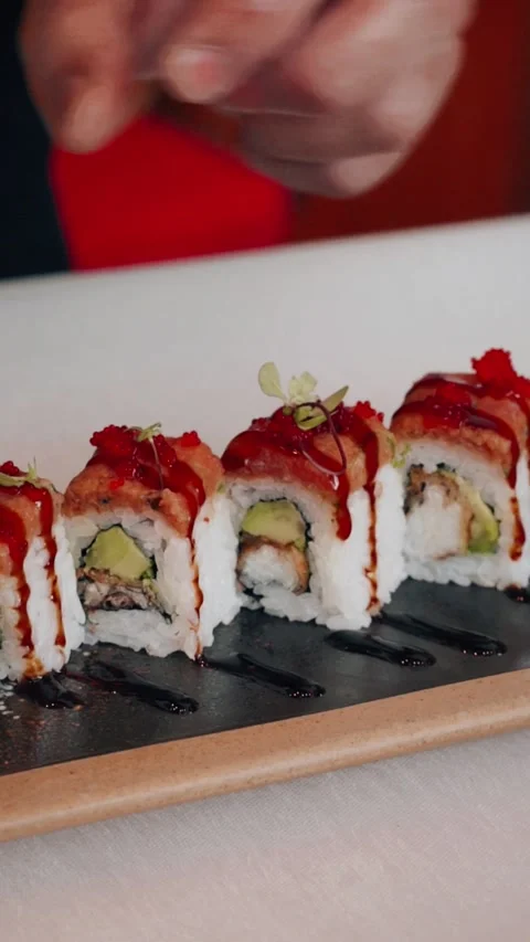 4K chef tongs plating green garnish on top sushi roll - vertical video Stock Footage 314682809